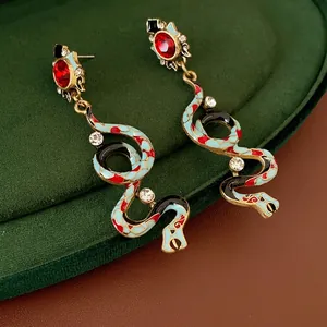 Vintage snake-shaped drop earrings with red stones and blue enamel on gold metal