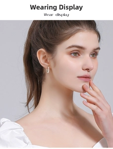 Close-up of S925 sterling silver hoop earrings with white stones worn by a model