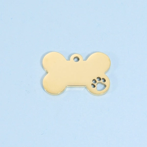 Close-up of golden bone-shaped pet tag with hollow paw print on blue background