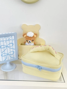 Pastel yellow makeup bag with blue zippers and embroidery for large travel storage