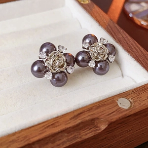 Detail of silver rose flower stud earrings with grey pearls and zircon on wood box