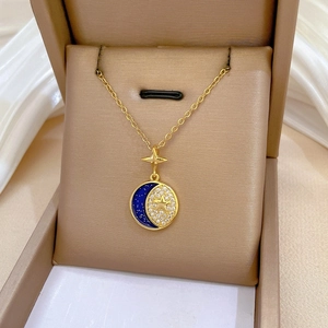 Detailed close-up of a crescent moon and star pendant with blue enamel and pavé zircons