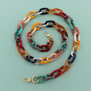 Overhead view of colorful acrylic chain with gold lobster clasps on mint background