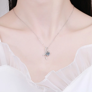 S925 silver bow pendant necklace with 1 carat moissanite worn by a model in soft light