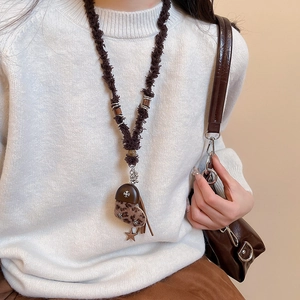 Détail du pendentif cœur en peluche vintage avec imprimé léopard et franges en cuir