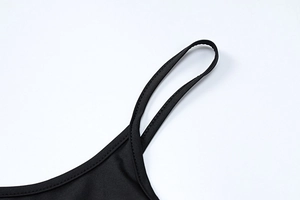 Detail view of adjustable thin straps and neck stitch on black lace slit dress