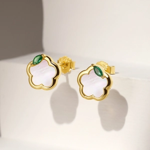 Macro shot of S925 silver flower stud with white shell and green marquise gemstone
