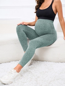 Detail of high-waisted maternity yoga pants in grey-green with premium knit texture
