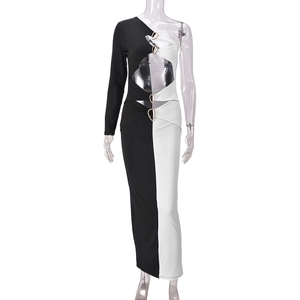 Détail de robe asymétrique bicolore avec découpes à la taille et anneaux métalliques