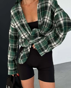 Close-up of green and black plaid shirt texture and sleeve detail on a female model
