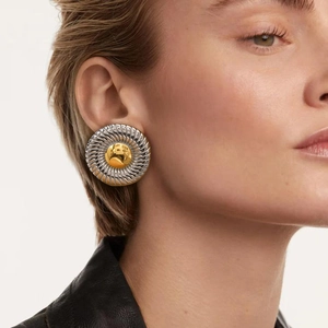 Exaggerated two-tone twisted circle earrings with gold sphere on a model