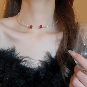 Silver choker necklace with red square zircons worn by a model in a close-up elegant view