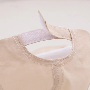 Detail of adjustable hook-and-loop strap on a breathable beige summer baby sun hat