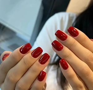 Glossy deep red short square round press-on nails shown on hand for professional look