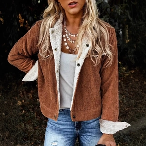 Detailed texture of brown corduroy fabric and warm white faux shearling collar on jacket