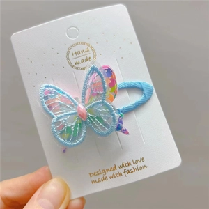 Detailed view of blue lace butterfly hair clip with colorful sequins and pink gemstone