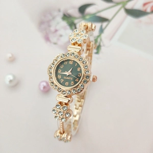 Macro detail of a floral gold bracelet watch with a green dial and sparkling rhinestones