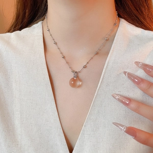 Detail view of a sparkling crystal sphere pendant on a silver-tone beaded chain necklace