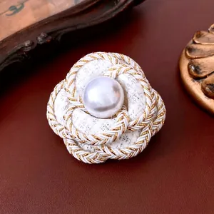 Elegant white tweed camellia flower brooch with pearl center and golden trim accents