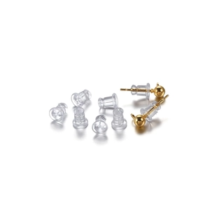 Detailed view of golden ball stud earrings with clear silicone safety earring back stoppers