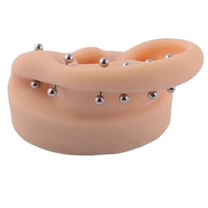 Surgical steel ball stud earrings for cartilage on realistic ear model display