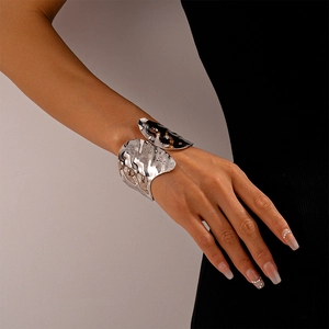 Detail of silver textured cuff bracelet showing mirror finish and hammered ripple design