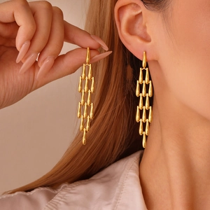 Long gold tiered teardrop earrings in 18K gold plated stainless steel on model