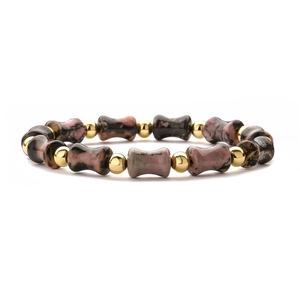 Detail of beaded bamboo joint bracelet with gold beads and textured natural pink stones