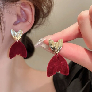 Vue détaillée de boucles d'oreilles queue de poisson en velours rouge et métal doré