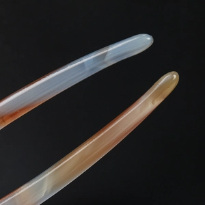Macro shot of smooth blue-grey and orange-brown acetate hair pin tips with natural texture