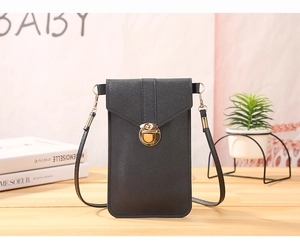 Detail of black crossbody phone bag with gold metal buckle on a rustic wooden desk