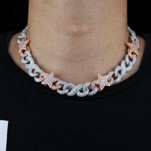 Close-up of iced out silver Cuban link necklace with rose gold star accents on neck