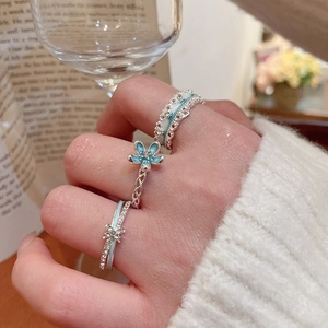 Three-piece ring set featuring a blue enamel flower pendant and sparkling rhinestones