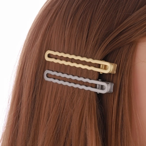 Minimalist wavy metal hair clips in matte gold and silver finish on hair