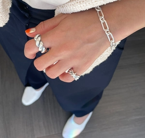 Close-up of minimalist 925 silver star ring and chain bracelet on model's hand