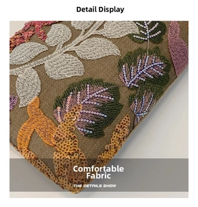Macro shot of detailed floral embroidery and shimmering sequins on a luxury evening clutch