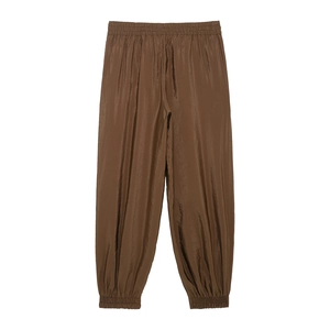 Detail view of brown glossy fabric texture on casual women's loose safari pants