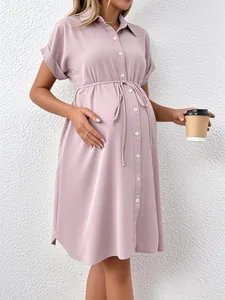 Detail of light pink maternity shirt dress with waist drawstring and button closure