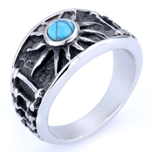 Macro shot of turquoise stone and sun-embossed pattern on oxidized metal ring