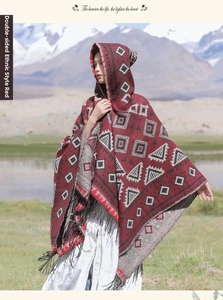Détail du poncho bohème rouge à capuche avec motifs géométriques et franges