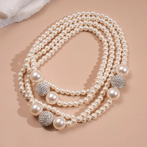 Multi-layer pearl necklace with silver crystal pavé spheres on a minimalist background