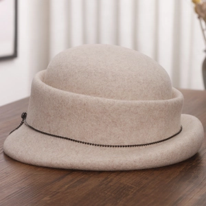 Detail of beige wool felt cloche hat featuring a rolled brim and delicate black bead chain