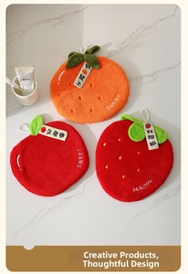 Detail of hanging coral fleece hand towels with orange apple and strawberry fruit designs