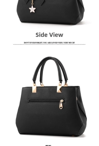 Detail of black pebbled leather handbag featuring gold hardware and a white star charm
