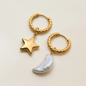 Detail of gold hammered hoop earrings with star pendant and baroque pearl drop charms