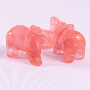 Close-up of pink crystal elephant carvings on textured fabric for home decor