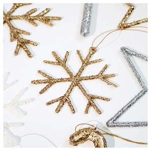 Close-up of glittery champagne gold snowflake ornaments for Christmas tree decoration