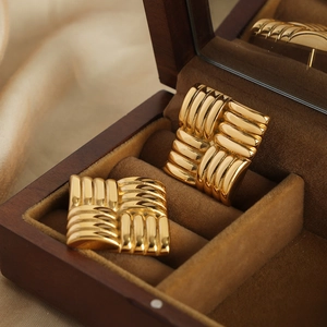 Vintage gold square earrings with woven textured stripes on luxury jewelry box