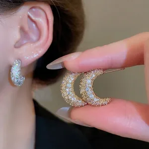 Elegant crescent moon stud earrings with sparkling pavé zircons in gold finish