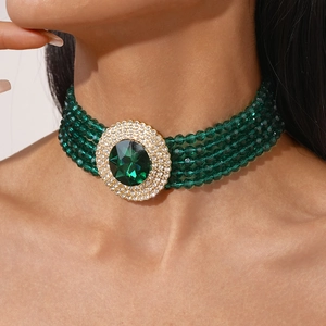 Macro detail of luxury multi-layer emerald green beaded choker with rhinestone pendant